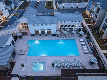 Drone image looking down at the pool and spa area at evening time.
